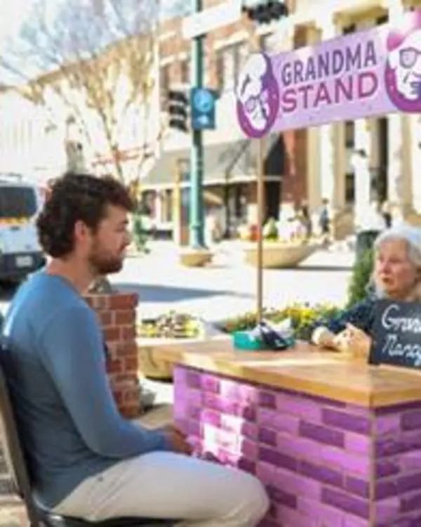 Grandma visit with young man at the Grandma Stand in Downtown McKinney.