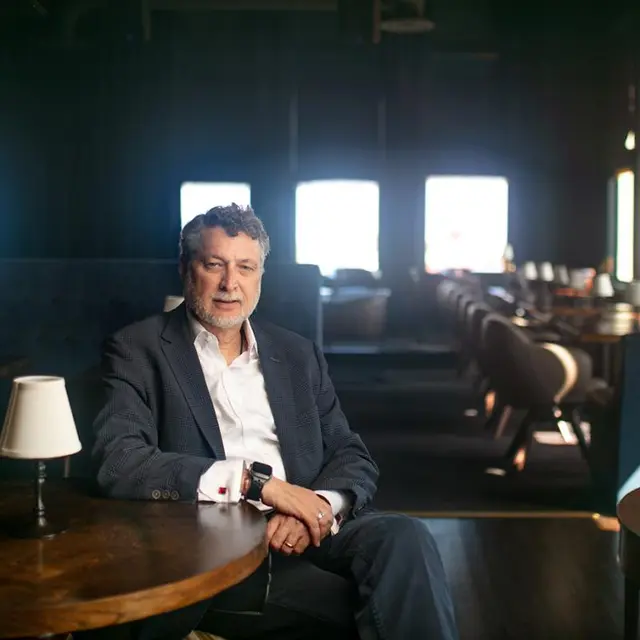 man sitting at a table in a quiet intimate restaurant setting - sunlight coming through windows