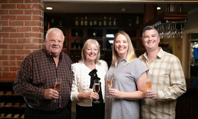 Older couple and younger couple holding wine glasses