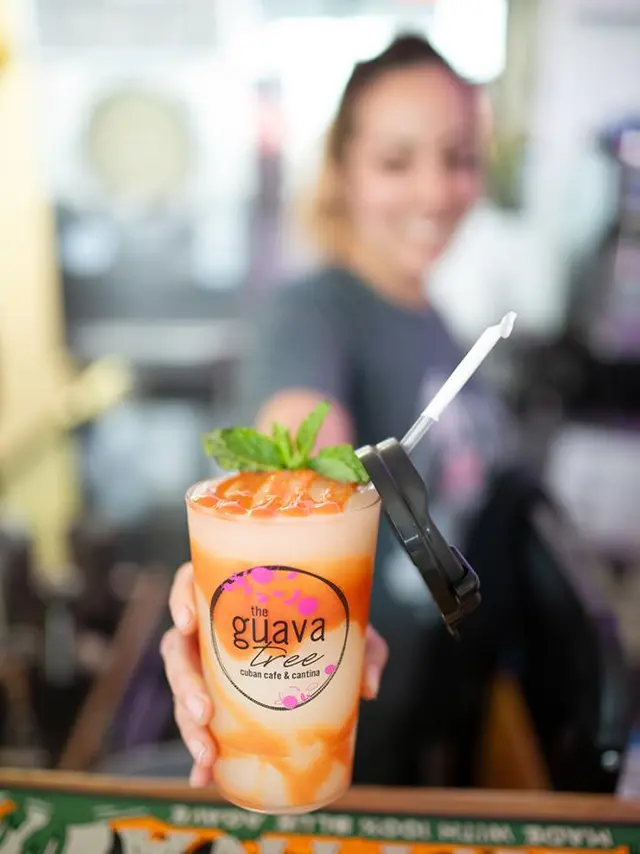 young woman reaching out with a swirled frozen cocktail