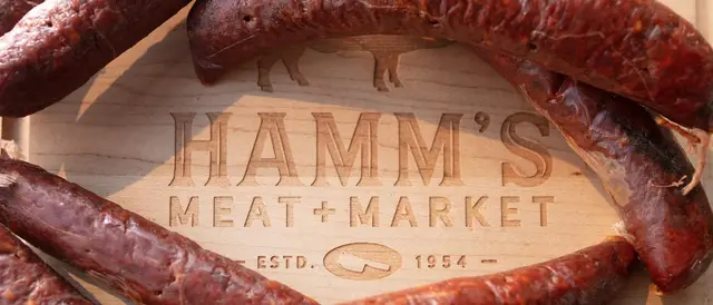 Cutting board engraved with Hamm's Meat + Market surrounded by sausage links