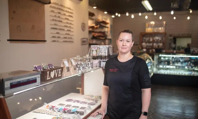 Laura King, owner of Goodies Texas, beside the candy case