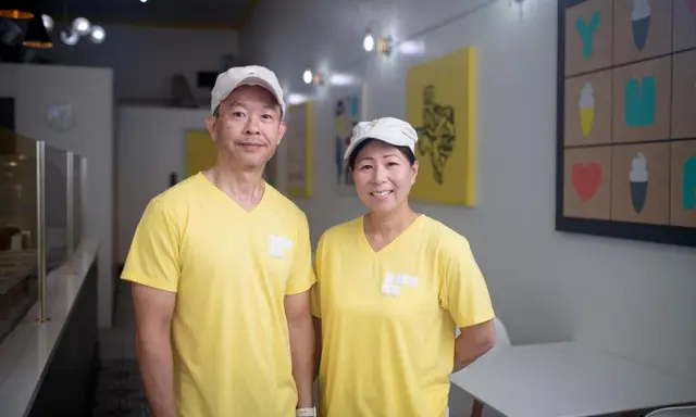 Asian couple in white ball caps and yellow shirts