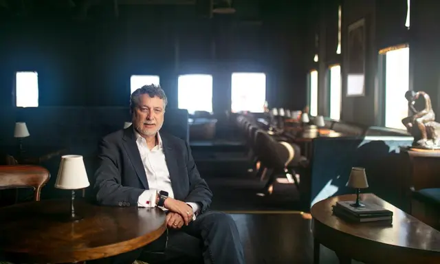 man sitting at a table in a quiet intimate restaurant setting - sunlight coming through windows
