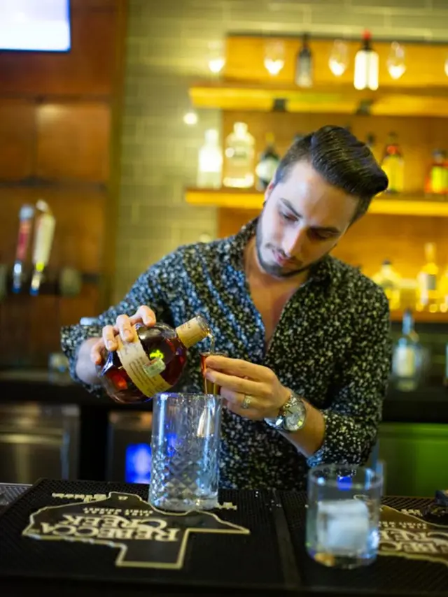 Sugarbacon bartender making cocktail at bar