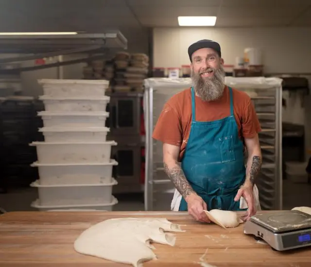 Baker working bread dough at Bresnan Bread & Pastry