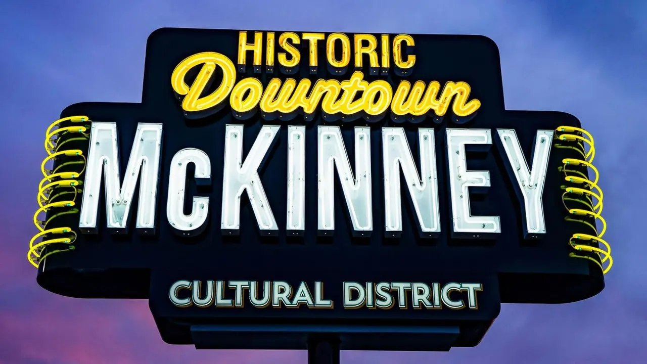 downtown McKinney neon sign with purple and blue sky