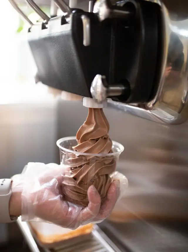 hands serving ice cream from soft serve machine