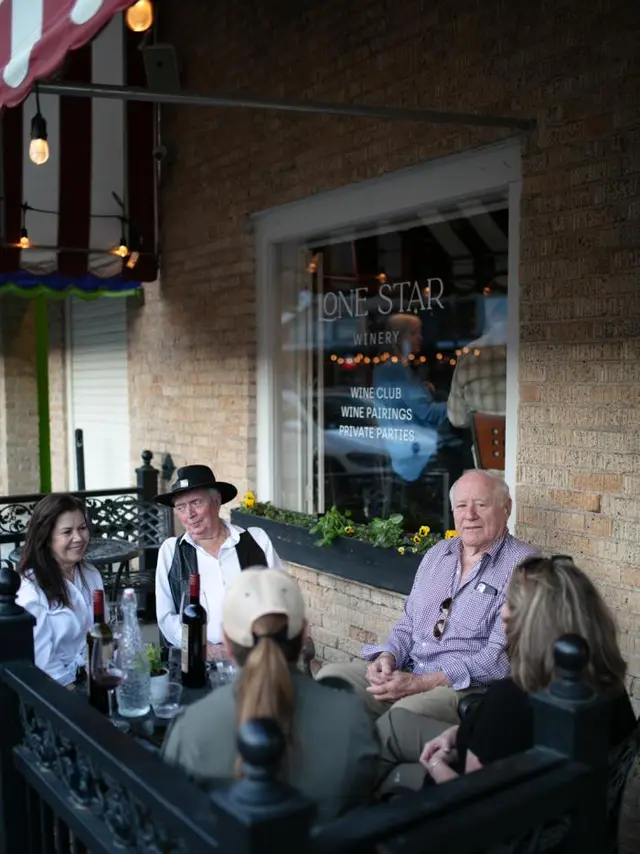 people enjoying wine on a sidewalk patio