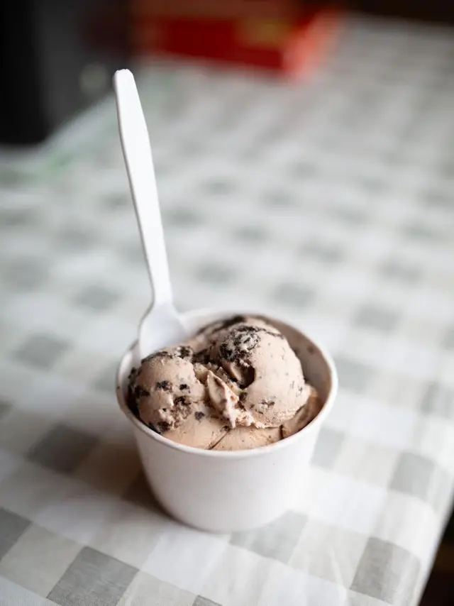 A cup of cookies and cream ice cream with a spoon in it