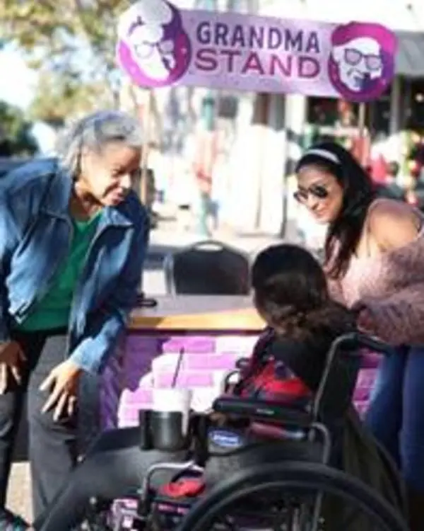 Grandma visits with two women, one in a wheelchair, in Downtown McKinney.