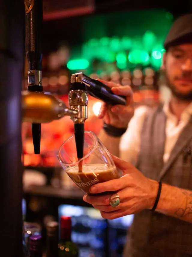 Man pouring a beer at a bar