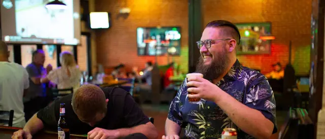 The Pub - two men sitting at the bar with drinks laughing