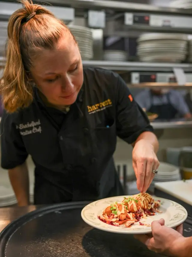 Female chef adds touches to plated food