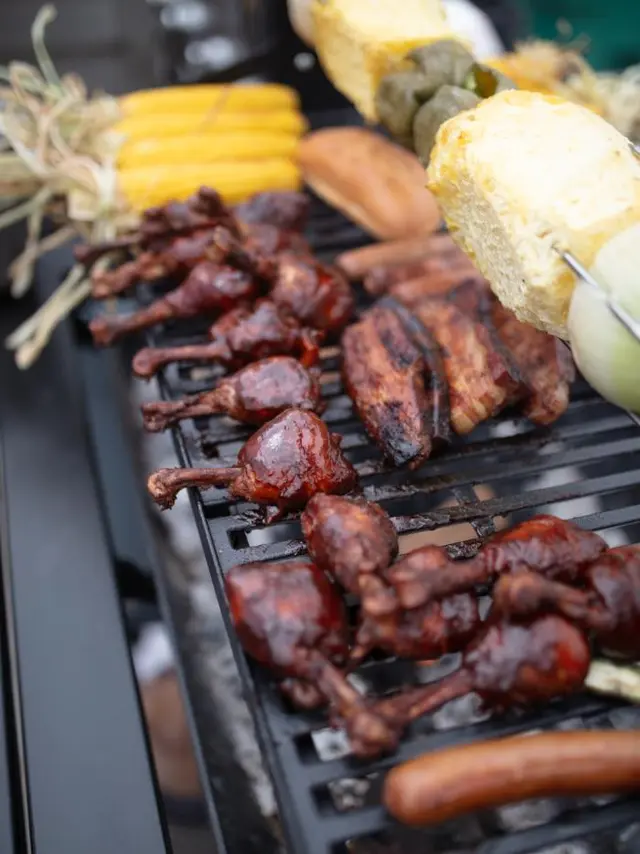 grill filled with meat and corn cobs