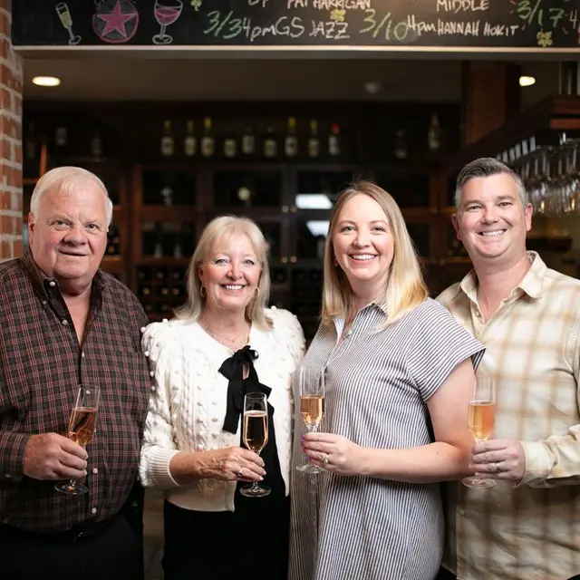 Older couple and younger couple holding wine glasses