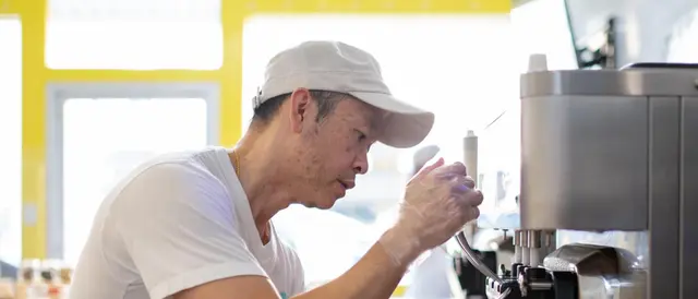 Miruku owner serving soft serve ice cream from machine